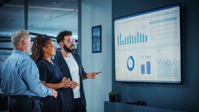 People looking at a screen with data.